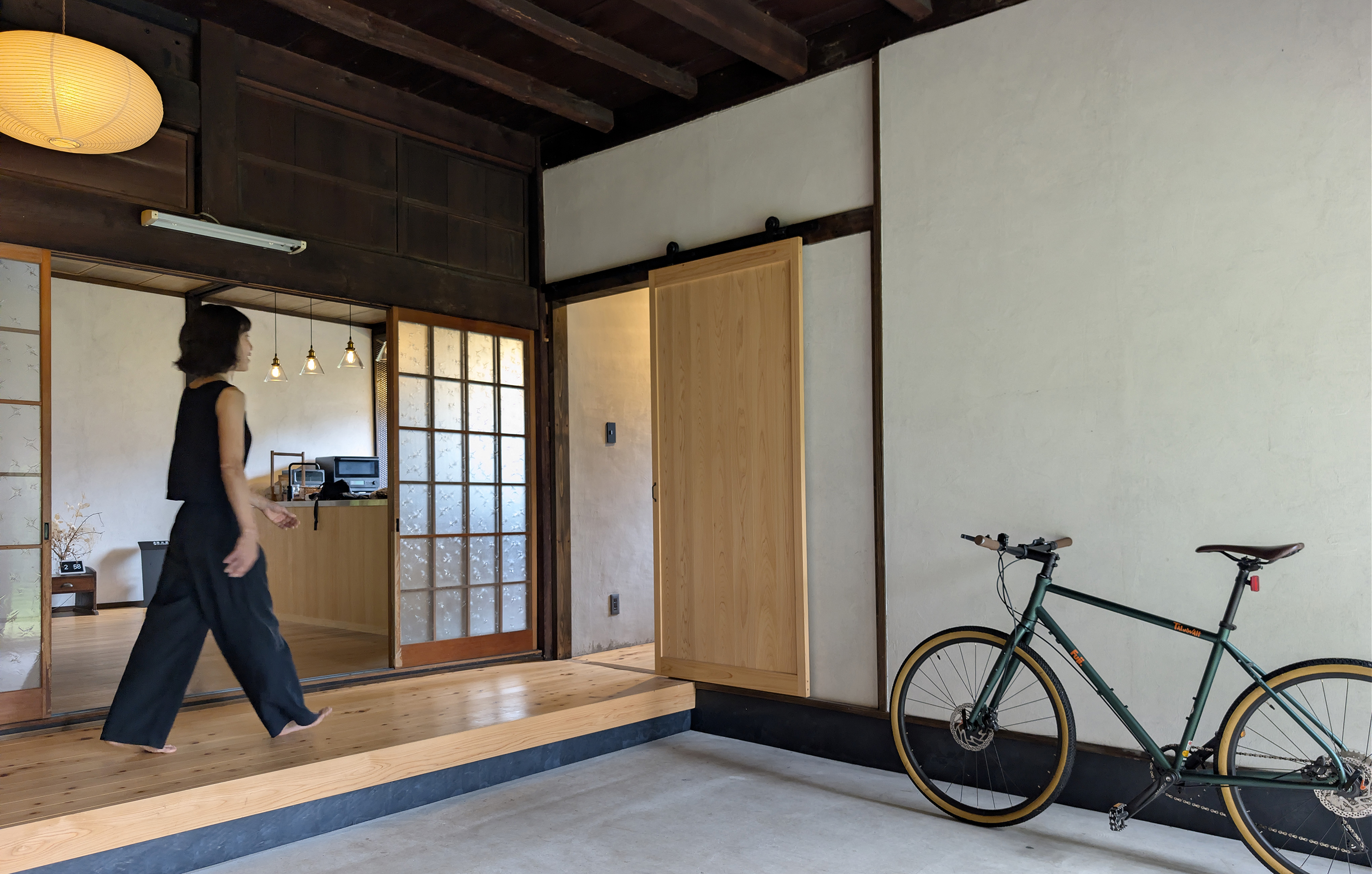 KinoMa entrance area with a green bicycle, paper lantern, and sliding wooden doors