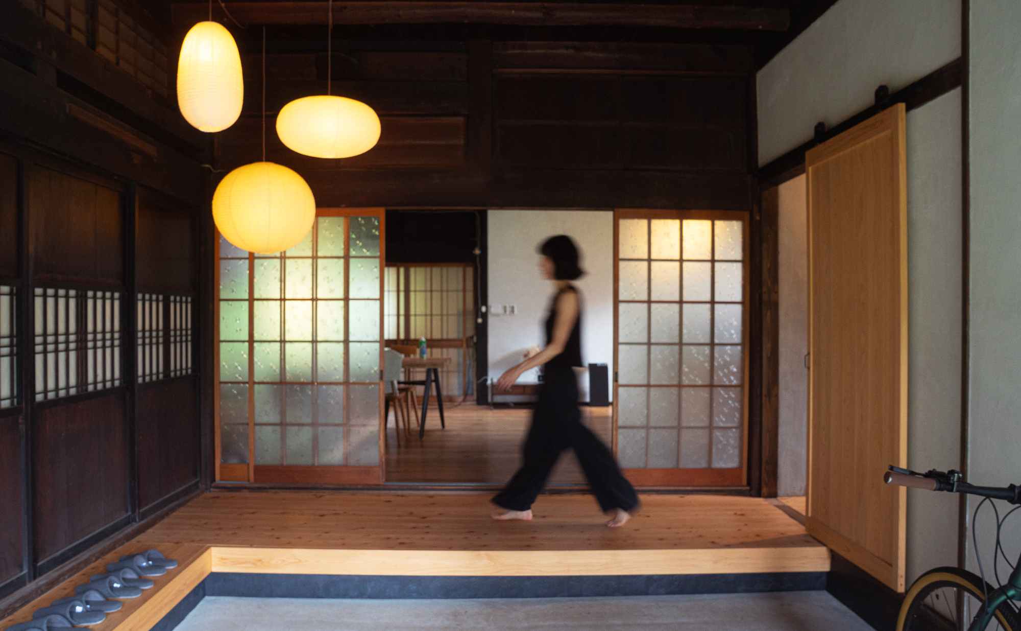 Traditional kominka interior with paper lanterns, shoji screens, and warm wooden floors
